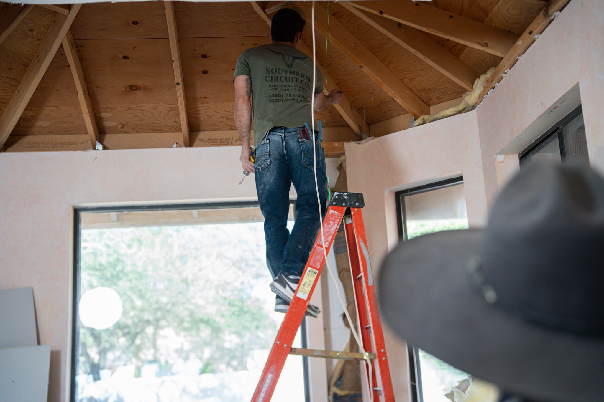 Southern Circuit Co. electrician wiring a vaulted ceiling on a custom home